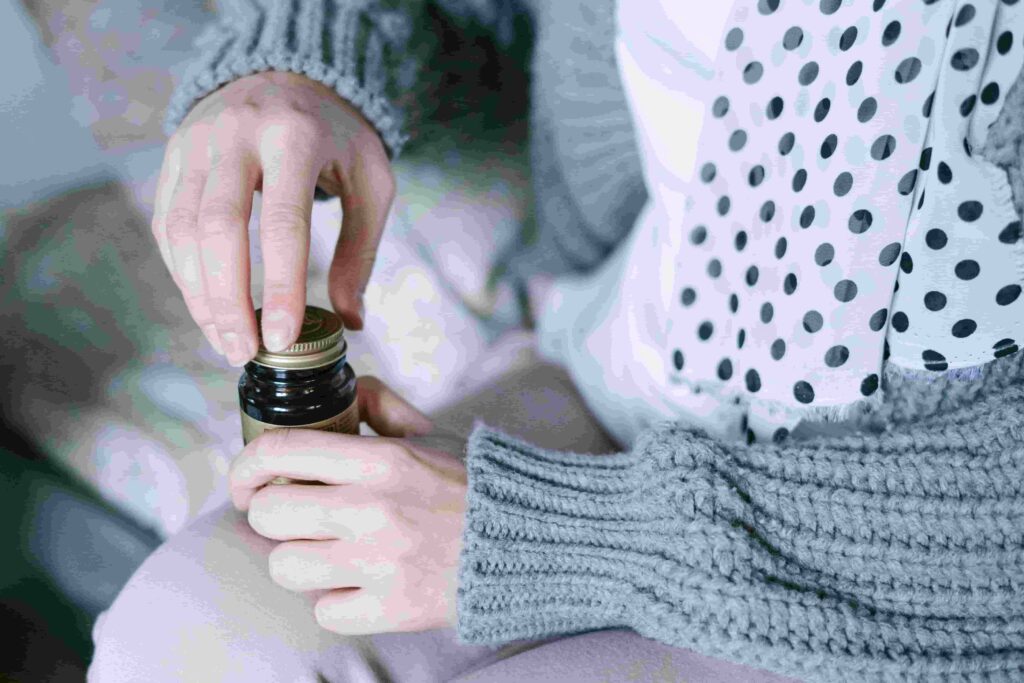 Woman holding vitamin D supplements for PCOS and hormonal balance support.